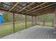 A large covered patio overlooks the spacious and grassy backyard at 13289 Joy Path, Brooksville, FL 34601