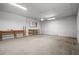 This shows the unfinished workshop area with a fan, shelving, and fluorescent lighting at 13289 Joy Path, Brooksville, FL 34601