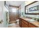 Bathroom with a glass-enclosed shower, granite countertop, and wood cabinets at 13419 Banner Rd, Spring Hill, FL 34609
