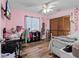 Bright bedroom features a ceiling fan, wood floors, and closet for storage at 13419 Banner Rd, Spring Hill, FL 34609
