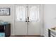 Charming white double front doors featuring sheer curtains, adding a touch of privacy and elegance to the entrance at 13419 Banner Rd, Spring Hill, FL 34609