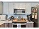 Updated kitchen with stainless steel appliances, grey cabinets, and granite countertops at 13419 Banner Rd, Spring Hill, FL 34609