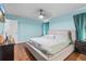 Bright bedroom featuring a ceiling fan, wood flooring, and serene blue walls at 13419 Banner Rd, Spring Hill, FL 34609