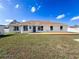 Rear exterior view of the house showing windows, patio, and fenced backyard at 14185 Dorado St, Spring Hill, FL 34609