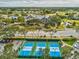 Aerial view showcasing pickleball courts and the clubhouse in a vibrant community setting at 18325 Whitacre Cir, Hudson, FL 34667
