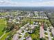 Aerial view of the home in a community featuring mature trees, manicured lawns, and winding roads at 18325 Whitacre Cir, Hudson, FL 34667