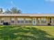 Manicured backyard with well maintained lawn and exterior view of the home's windows and back door at 18325 Whitacre Cir, Hudson, FL 34667