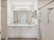 Bright bathroom featuring double sinks, generous mirror, and walk-in shower at 18325 Whitacre Cir, Hudson, FL 34667