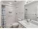 Cozy bathroom featuring tiled walk-in shower, neutral countertop, framed mirror, and white fixtures at 18325 Whitacre Cir, Hudson, FL 34667