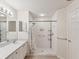 Bathroom featuring walk-in shower with white tiles, updated fixtures, and a single vanity at 18325 Whitacre Cir, Hudson, FL 34667