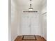 Inviting entryway featuring double doors, hardwood floors, and an overhead transom window at 18325 Whitacre Cir, Hudson, FL 34667