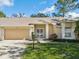 Charming single-story home with a well-maintained lawn, attached garage, and inviting front entrance at 18325 Whitacre Cir, Hudson, FL 34667