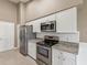 Kitchen featuring stainless steel appliances, granite counters, and white cabinets at 18325 Whitacre Cir, Hudson, FL 34667