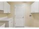 Well-lit laundry room with storage cabinets and a utility sink at 18325 Whitacre Cir, Hudson, FL 34667