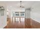 Open-concept living room featuring hardwood floors, a ceiling fan, and large windows for natural light at 18325 Whitacre Cir, Hudson, FL 34667