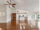 Bright open-concept living room featuring hardwood floors, and a view of the modern kitchen at 18325 Whitacre Cir, Hudson, FL 34667