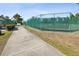A sidewalk leading to fenced tennis courts in a well-maintained recreational area at 18325 Whitacre Cir, Hudson, FL 34667