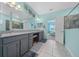 Bright bathroom with double sinks, granite countertops, vanity seating, and tiled flooring at 19770 Tattnall Way, Brooksville, FL 34601