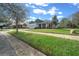 Charming single-story home with a well-manicured lawn, sidewalk and blue accents at 19770 Tattnall Way, Brooksville, FL 34601