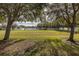 Expansive backyard with lush green grass, mature trees, and a white fence surrounding the property at 4412 Caliquen Dr, Brooksville, FL 34604