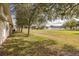 View of the backyard with a large grassy area and a white fence in the background at 4412 Caliquen Dr, Brooksville, FL 34604