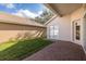 Backyard features a brick patio, lawn, and exterior walls, with a glimpse of the home's tile roof at 4412 Caliquen Dr, Brooksville, FL 34604