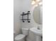 Bathroom with a pedestal sink, decorative shelving, and modern fixtures at 4412 Caliquen Dr, Brooksville, FL 34604