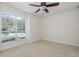 Bedroom with a large window allowing natural light and neutral carpet at 4412 Caliquen Dr, Brooksville, FL 34604