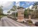 Inviting entrance to Hernando Oaks featuring a decorative sign and palm tree lined street at 4412 Caliquen Dr, Brooksville, FL 34604