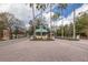 Hernando Oaks roundabout featuring a guard house and multiple palm trees at 4412 Caliquen Dr, Brooksville, FL 34604