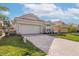 Well-maintained home exterior featuring a brick driveway, stone accents, and manicured lawn at 4412 Caliquen Dr, Brooksville, FL 34604