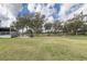 Picturesque view from the patio of the golf course with mature trees and manicured green grass at 4412 Caliquen Dr, Brooksville, FL 34604