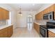 Bright kitchen area featuring tile floors and wooden cabinets with a view of the front entrance at 4412 Caliquen Dr, Brooksville, FL 34604