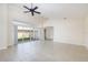 Spacious living room with tile floors, high ceilings, ceiling fan, and sliding glass doors to the backyard at 4412 Caliquen Dr, Brooksville, FL 34604