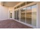 Open-air patio with a brick floor and large sliding glass doors to the home's interior at 4412 Caliquen Dr, Brooksville, FL 34604