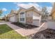 Home exterior featuring stone accents, lush plants and blue sky at 4412 Caliquen Dr, Brooksville, FL 34604