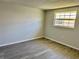 This bedroom features gray walls, a window and gray, wood-look vinyl plank flooring at 4930 Getner St, New Port Richey, FL 34652
