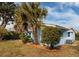 Inviting home exterior features lush landscaping, vibrant plantings and light-blue colored siding at 5830 34Th N Ave, St Petersburg, FL 33710