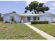 Charming, light blue single-story home with well-manicured lawn and inviting pathway to the front door at 5830 34Th N Ave, St Petersburg, FL 33710