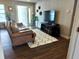 This living room includes a leather couch, a black TV console, and modern decor and wood flooring at 5830 34Th N Ave, St Petersburg, FL 33710