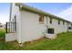 Exterior side view of a white stucco home with lush green grass and an air conditioning unit at 6028 Wilds Dr # 6A, New Port Richey, FL 34653