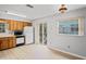 Bright kitchen featuring wood cabinets, white appliances, and sliding glass door to outdoor balcony at 6028 Wilds Dr # 6A, New Port Richey, FL 34653