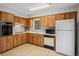 Traditional kitchen with wood cabinetry and white appliances at 6028 Wilds Dr # 6A, New Port Richey, FL 34653