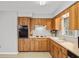 Charming kitchen featuring wood cabinetry and white appliances at 6028 Wilds Dr # 6A, New Port Richey, FL 34653