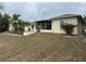 Backyard view of home featuring a screened patio and mature palm tree at 6419 India Dr, Spring Hill, FL 34608