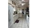 A view of the kitchen shows tile flooring, a white refrigerator, and granite countertops at 6419 India Dr, Spring Hill, FL 34608