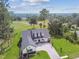 An aerial view of the house with its well-manicured lawn and brick driveway on a golf course at 6452 Summit View Dr, Brooksville, FL 34601