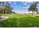 A well landscaped backyard with a putting green, grass, and trees at 6452 Summit View Dr, Brooksville, FL 34601