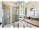 Well-lit bathroom with a glass-enclosed shower, white vanity, dark hardware, and neutral color scheme at 6452 Summit View Dr, Brooksville, FL 34601