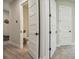 Hallway view showcasing an open powder room and access to other rooms with white doors and hardware at 6452 Summit View Dr, Brooksville, FL 34601